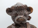 a wooden statue of a bear with a hat on