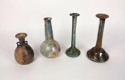 four different colored vases sitting next to each other on a white surface