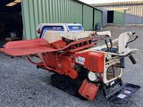 a red tractor is parked in front of a building