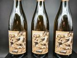 trois bouteilles de vin sont posées sur un bloc noir