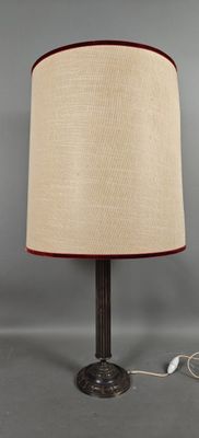 un gros plan d'une lampe posée sur une table, dont le cordon est branché