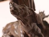 bronze statue of a woman and a dog on a table