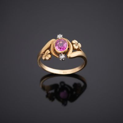 une bague en or jaune sertie d'un saphir rose et de diamants