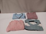 several knitted hats and sweaters sitting on a white table
