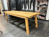 une table en bois dans une pièce où de nombreuses paires de chaussures sont accrochées au mur