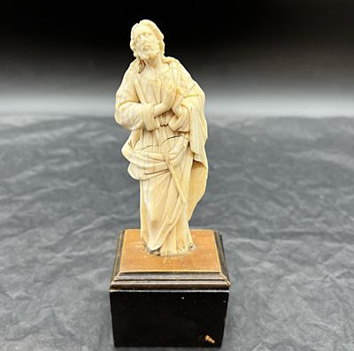une figurine ancienne en ivoire sculpté représentant une femme tenant un panier