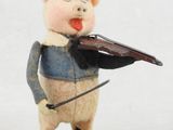 une petite figurine représentant un cochon jouant du violon