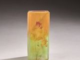 a small glass vase with flowers painted on it sitting on a table