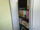 an image of a room with a refrigerator and a bookcase