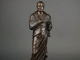 a bronze statue of a man holding a baby on a marble base