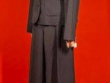 a mannequin in a suit on display on a red background