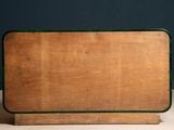 an old wooden table with a green top on a table