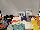 une table sur laquelle sont posés tout un tas de vêtements pour bébés