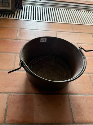 un seau noir posé par terre devant une fenêtre