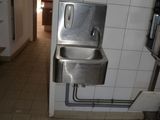 a bathroom with a sink and a hand dryer on the wall