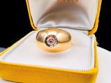a gold ring with a diamond in it sitting in a box