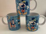 trois tasses Mickey Mouse posées sur une table blanche