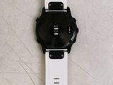 a black and white watch sitting on a white surface