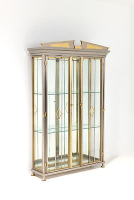 une grande vitrine aux portes en verre et aux finitions dorées