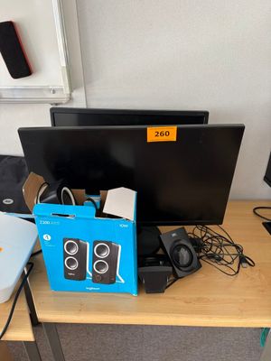 un bureau sur lequel se trouvent un ordinateur portable, un écran et d'autres appareils électroniques