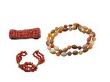 Deux bracelets et un collier de perles sont présentés sur un fond blanc