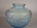 a blue glass vase that is sitting on a table