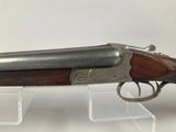 an old gun on display on a clear acrylic stand