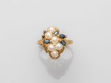 a gold ring with pearls and sapphires