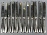 six silverplated knives and six knives on a table