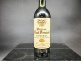 une vieille bouteille de vin rouge posée sur une boîte noire