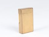 a gold lighter sitting on top of a white surface