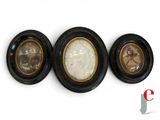 three black and gold framed pictures of a man and a woman