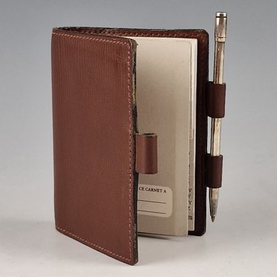 wallet with pen and notepad in it sitting open on a table