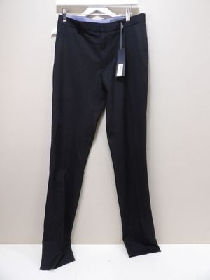 un pantalon noir suspendu à un cintre devant un mur blanc