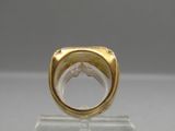 an image of a gold ring sitting on top of a clear stand