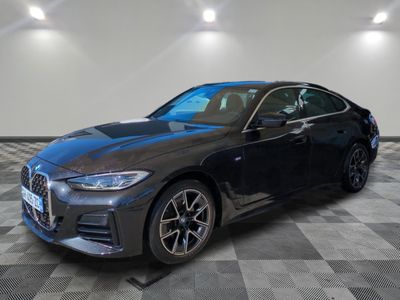 a black bmw sedan parked on a checkered floor in a showroom