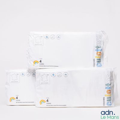 trois paquets de couches empilés les uns sur les autres sur une surface blanche