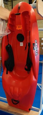 un kayak rouge posé sur un support dans une pièce
