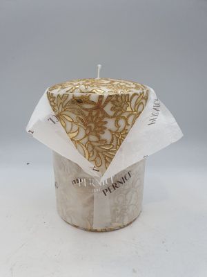 une bougie ornée d'un motif doré et blanc, posée sur une surface blanche