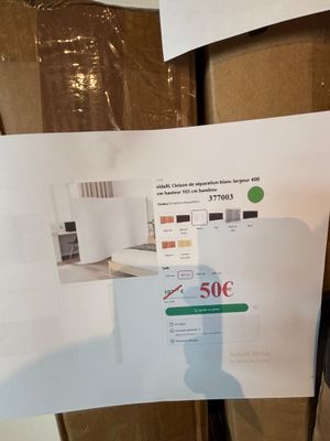 une personne tenant une feuille de papier sur laquelle figure une photo d'une cuisine