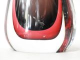a glass vase with a red and black design on it