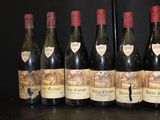 six bottles of wine are lined up in a row on a table