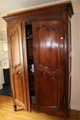 une photo d'une grande armoire en bois dans un salon