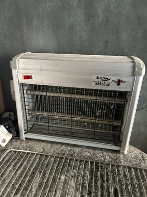 an air conditioner sitting on top of a metal grate next to a wall