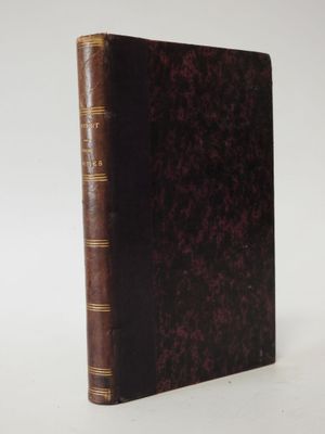 a brown book sitting on top of a table next to a white wall
