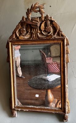 un miroir accroché au mur dans lequel on voit une poupée