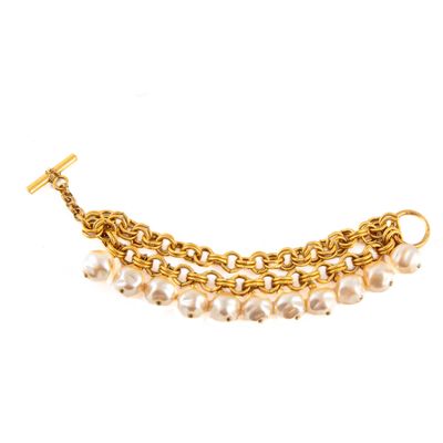 un gros plan d'un bracelet en chaîne dorée orné de perles