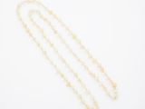 un collier plaqué or orné d'une longue chaîne de perles