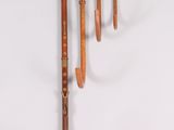 four wooden flutes are lined up against a white background