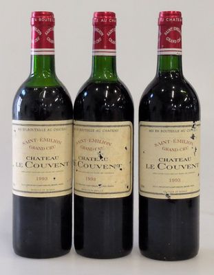 three bottles of wine are lined up on a white surface